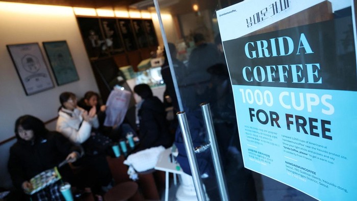 Protestors taking part in a rally calling for the impeachment of South Korean President Yoon Suk Yeol, who declared martial law, which was reversed hours later, rest at a cafe that offers free drinks and shelter against cold weather in front of the National Assembly in Seoul, South Korea, December 14, 2024. REUTERS/Kim Hong-Ji