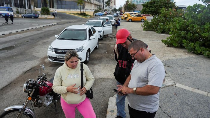 A driver checks the line as he waits for gasoline in Havana, Cuba, December 13, 2024. REUTERS/Alexandre Meneghini