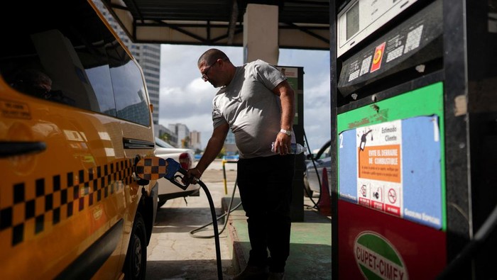 A driver checks the line as he waits for gasoline in Havana, Cuba, December 13, 2024. REUTERS/Alexandre Meneghini