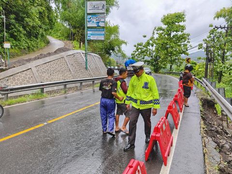 Petugas saat memasang barrier di bahu Jalan Jogja-Wonosari, Piyungan, Bantul, yang longsor, Sabtu (14/12/2024).
