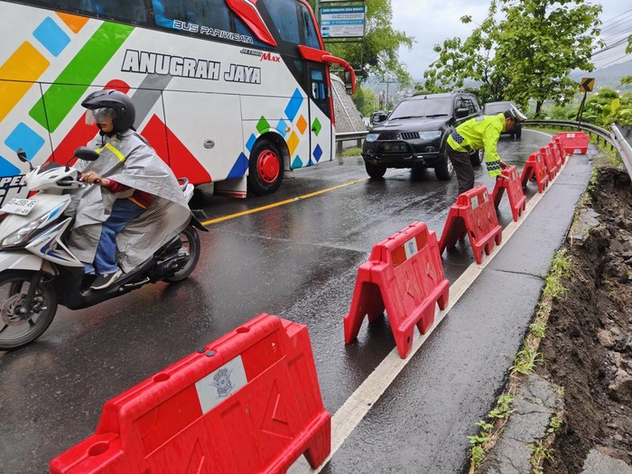 Petugas saat memasang barrier di bahu Jalan Jogja-Wonosari, Piyungan, Bantul, yang longsor, Sabtu (14/12/2024).