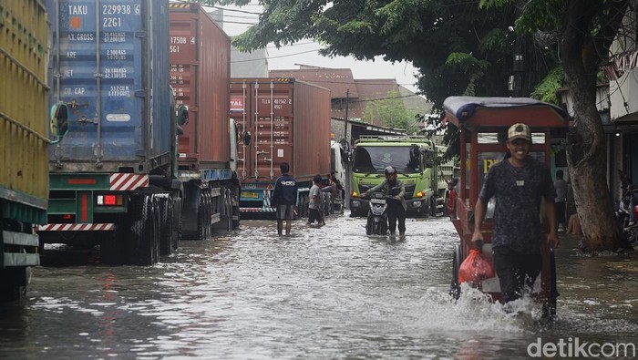 Banji Rob Genangi Akses ke Pelabuhan Sunda Kelapa Truk kontainer menembus banjir air laut pasang (rob) di depan gerbang Pelabuhan Sunda Kelapa, Jl Lodan Raya, Jakarta Utara, Minggu (15/12/2024).