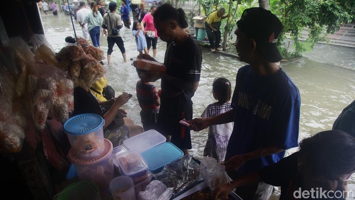 Warga beraktifitas di tengah banjir air laut pasang (rob) di pemukiman warga RT 01/08, Ancol, Pademangan, Jakarta Utara, Minggu (15/12/2024).