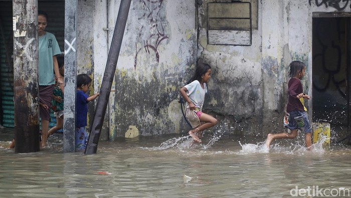 Warga beraktifitas di tengah banjir air laut pasang (rob) di pemukiman warga RT 01/08, Ancol, Pademangan, Jakarta Utara, Minggu (15/12/2024).