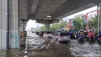 Sejumlah pengendara nekat menerobos genangan air. Namun, tak sedikit yang memilih berhenti dan menepi di median jalan sambil berteduh.