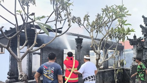 Petugas Damkar Jembrana saat melakukan upaya pemadaman api yang membakar rumah warga di Banjar Pasar, Jembrana, Minggu (15/12/2024).