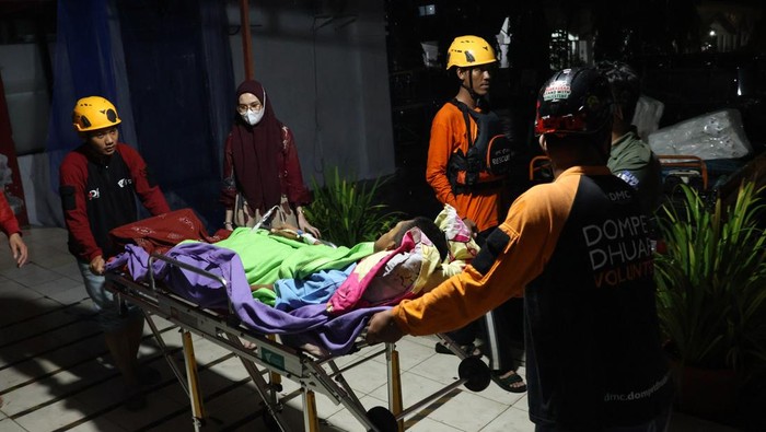 Relawan mengangkat pasien ke mobil ambulans saat evakuasi akibat banjir yang merendam beberapa fasilitas di Rumah Sakit Faisal, Makassar, Sulawesi Selatan, Minggu (15/12/2024). Sedikitnya 26 pasien di rumah sakit tersebut dievakuasi ke beberapa rumah sakit lain yang tidak terdampak banjir sementara pasien lainnya dipindahkan ke ruangan yang masih aman dari genangan air. ANTARA FOTO/Arnas Padda/nym.