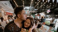 Liburan ke Bangkok, pasangan yang menikah tahun 2019 itu mampir ke Jodd Fairs untuk berburu banyak kuliner menarik. Tangan mereka pun penuh dengan plastik jajanan. Foto: Instagram @sitibadriahh / @krishianabah