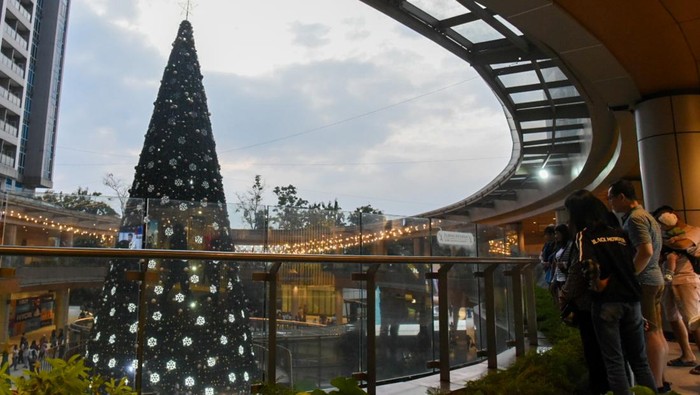 Pengunjung melihat pohon Natal setinggi 21 meter di salah satu pusat perbelanjaan di Medan, Sumatera Utara, Minggu (15/12/2024). Sejumlah pusat perbelanjaan di Medan mulai menghias tempat mereka dengan ornamen kemeriahan Natal 2024 untuk memikat pengunjung. ANTARA FOTO/Fransisco Carolio/nym.