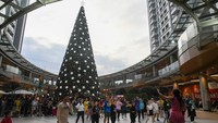 Pengunjung melintas di dekat pohon Natal setinggi 21 meter di salah satu pusat perbelanjaan di Medan, Sumatera Utara, Minggu (15/12/2024). 