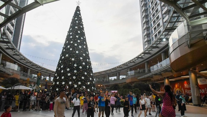 Pengunjung melihat pohon Natal setinggi 21 meter di salah satu pusat perbelanjaan di Medan, Sumatera Utara, Minggu (15/12/2024). Sejumlah pusat perbelanjaan di Medan mulai menghias tempat mereka dengan ornamen kemeriahan Natal 2024 untuk memikat pengunjung. ANTARA FOTO/Fransisco Carolio/nym.