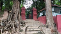 Pintu masuk area makam Pangeran Suryanegara Cirebon yang diapit dua pohon besar dan gapura kembar.