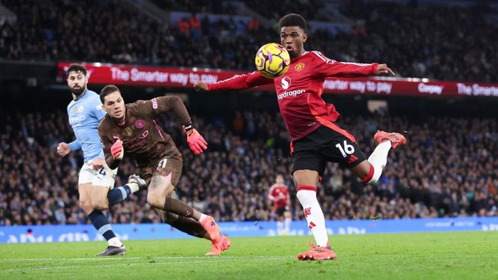 MANCHESTER, ENGLAND - DECEMBER 15: Amad Diallo of Manchester United scores their sides second goal during the Premier League match between Manchester City FC and Manchester United FC at Etihad Stadium on December 15, 2024 in Manchester, England. (Photo by Alex Livesey - Danehouse/Getty Images)
