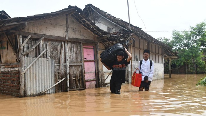 Banjir Besar Rendam Ponorogo, Akibat Luapan Sungai dan Tanggul Jebol Petugas gabungan memotong pohon tumbang yang menghalangi jalan saat terjadi banjir di Ponorogo, Jawa Timur, Senin (16/12/2024). Banjir akibat luapan sejumlah sungai dan jebolnya tanggul mengakibatkan tujuh wilayah kecamatan di daerah itu terendam, dua warga tewas terseret arus banjir, ratusan warga mengungsi, sejumlah ruas jalan dan ratusan rumah terendam, serta beberapa sekolah diliburkan. ANTARA FOTO/Siswowidodo/aww.