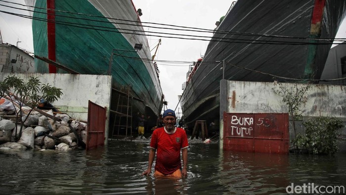 Sejumlah warga menerobos banjir komplek pergudangan galangan kapal Muara Angke, Jakarta Utara, Senin (16/12/2024).