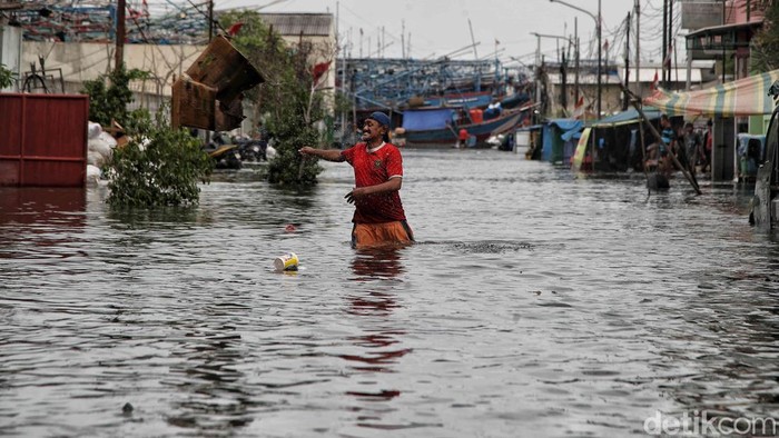 Banjir Rob Setinggi 80 Cm Rendam Komplek Galangan Kapal Muara Angke Sejumlah warga menerobos banjir komplek pergudangan galangan kapal Muara Angke, Jakarta Utara, Senin (16/12/2024).
