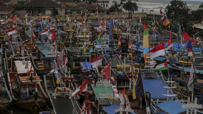 Warga berjalan di tumpukan sampah yang terbawa gelombang tinggi di Desa Teluk, Labuan, Kabupaten Pandeglang, Banten, Senin (16/12/2024). Gelombang tinggi yang terjadi di perairan Banten sejak beberapa hari terakhir menyebabkan sejumlah bangunan di kawasan pesisir rusak, menumpuknya sampah akibat terbawa gelombang, serta nelayan tidak dapat melaut untuk sementara waktu. ANTARA FOTO/Angga Budhiyanto/Spt.