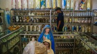 Perajin menyimpan patung rohani yang telah diwarnai ke tempat pengeringan di industri Algonz Collection. Tidak hanya membuat patung, industri Algonz Collection juga menawarkan jasa perbaikan patung yang telah rusak.
