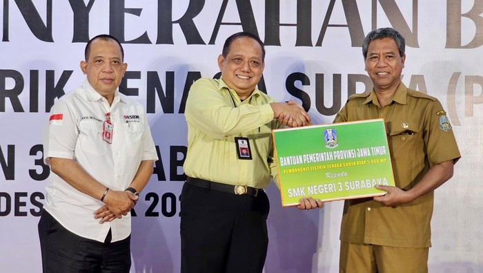 Kadis ESDM Jatim Aris Mukiyono menyerahkan bantuan PLTS atap ke Kepala SMKN 2 dan SMKN 3 Surabaya.