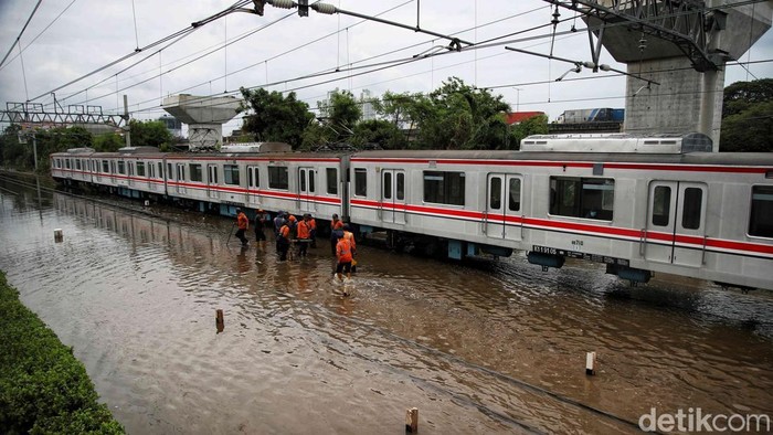 Penampakan Banjir Rob Rendam Perlintasan KRL Dekat JIS Rangkaian KRL melintas pelan di perlintasan kereta di Jalan R.E. Martadinata, Jakarta, Senin (16/12/2024). Sejumlah kereta melintas pelan setelah jalur yang menghubungkan stasiun Tanjung Priok dengan stasiun Jakarta Kota terendam banjir rob dengan ketinggian sekitar 10 sentimeter.
