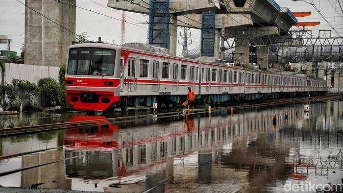 Rangkaian KRL melintas pelan di perlintasan kereta di Jalan R.E. Martadinata, Jakarta, Senin (16/12/2024). Sejumlah kereta melintas pelan setelah jalur yang menghubungkan stasiun Tanjung Priok dengan stasiun Jakarta Kota terendam banjir rob dengan ketinggian sekitar 10 sentimeter.