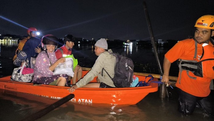 Petugas mengevakuasi warga terdampak banjir di Jalan Swadaya Mas, Makassar.