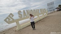 Wisatawan berswafoto di tulisan Sanggar Beach. Untuk dapat masuk ke area pantai, pengunjung perlu membayar tiket masuk dan biaya parkir.