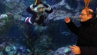 Aksi penyelam yang mengenakan helm selam lengkap ini menarik perhatian anak-anak hingga orang dewasa.