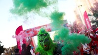 Seorang pria berpakaian seperti Grinch ikut serta dalam Lomba Sinterklas di Kota Meksiko. REUTERS/Raquel Cunha