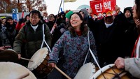Warga Korea Selatan merayakan kemenangan usai parlemen Korsel meloloskan mosi pemakzulan terhadap Presiden Yoon Suk Yeol di depan Majelis Nasional di Seoul, Sabtu (14/12/2024). REUTERS/Kim Soo-hyeon