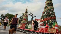 Pejalan kaki melintas di samping hiasan pohon natal di kawasan Bundaran Besar, Palangka Raya, Kalimantan Tengah, Senin (16/12/2024). 