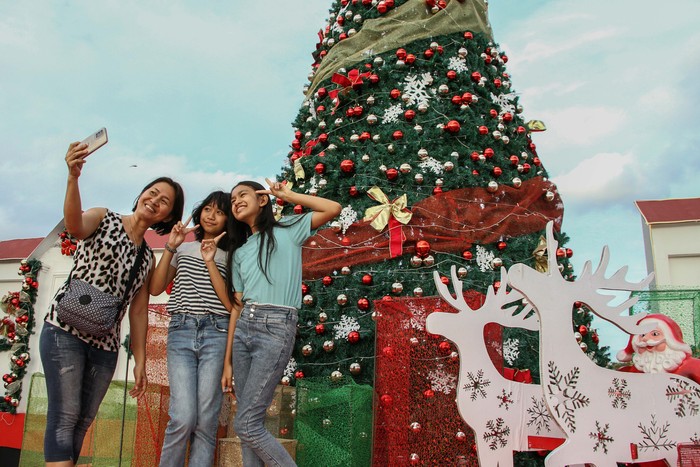 Pejalan kaki melintas di samping hiasan pohon natal di kawasan Bundaran Besar, Palangka Raya, Kalimantan Tengah, Senin (16/12/2024). Pemprov Kalteng memasang pohon dan hiasan natal sebagai tempat photobooth di kawasan tersebut guna menyambut perayaan Hari Natal dan Tahun Baru 2025. ANTARA FOTO/Auliya Rahman/Spt.