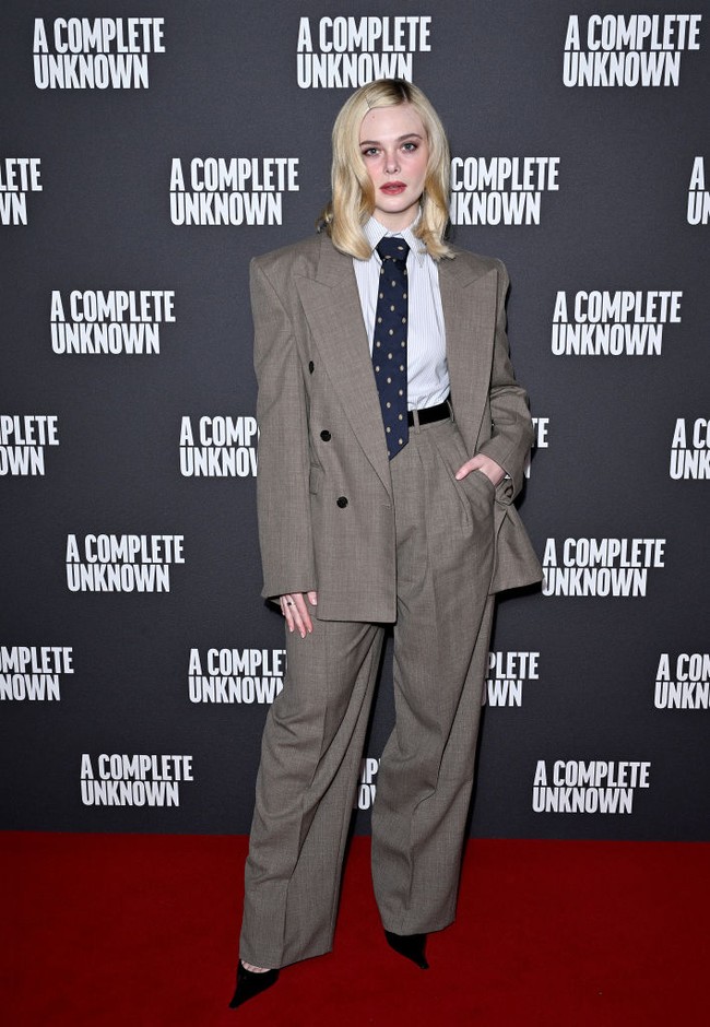 Mengenakan setelan jas lengkap dengan kemeja dan dasi, Elle Fanning memadukan kesan masculine tailoring dengan sentuhan feminin elegan khas dirinya. Foto: Max Cisotti/Dave Benett/WireImag/Dave Benett