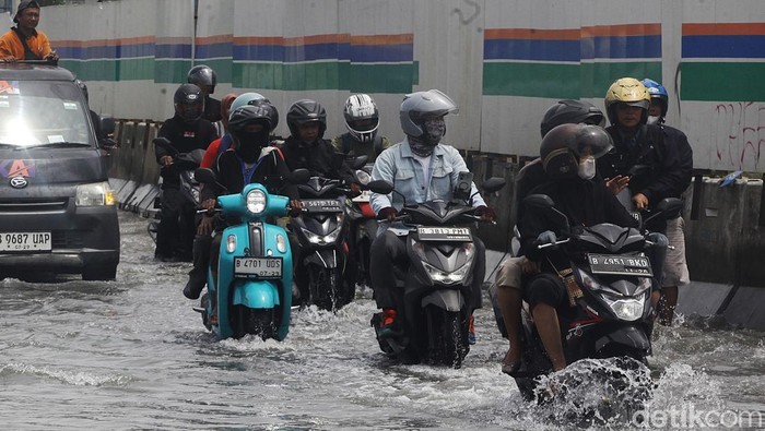 Pengendara melintasi banjir air laut pasang (rob) yang menggenangi jalan RE Martadinata tepatnya di depan JAkarta International Stadium (JIS), Jakarta Utara, Selasa (17/10/2024). Puncak rob pada pukul 09.00 WIB hingga 10.00 WIB. Air mulai surut pada pukul 11.00 WIB. Fenomena rob terjadi karena tanggal bulan purnama ataupun bulan mati. Sejumlah wilayah di Jakarta Utara juga terendam rob seperti di Muara Angke dan Marunda.