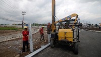 Pekerja menggunakan alat berat memasang pembatas jalan di Gerbang Tol Prambanan, Jogonalan, Klaten, Jawa Tengah, Selasa (17/12/2024).