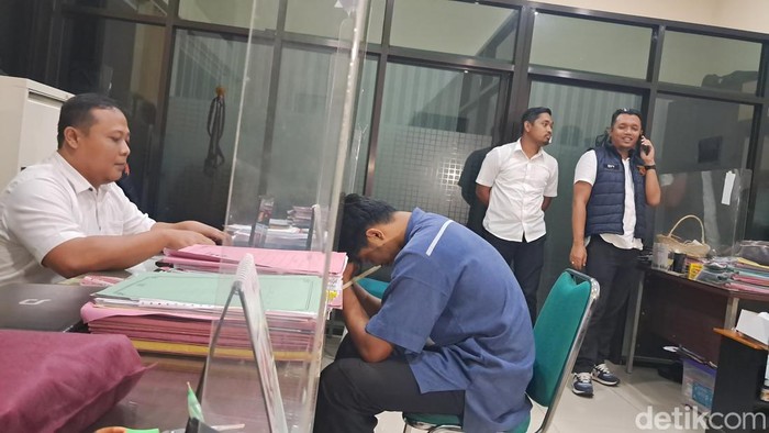 Tersangka menundukkan kepala saat hendak dimintai keterangan penyidik di Sat Reskrim Polres Boyolali, Selasa (17/12/2024) malam.