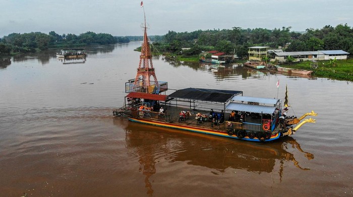 Perahu penyeberangan antarkabupaten di Sungai Brantas Nganjuk Perahu penyebarangan melintasi Sungai Brantas di Jatikalen, Nganjuk, Jawa Timur, Selasa (17/12/2024). Transportasi perahu penyeberangan yang digunakan warga sebagai lintasan alternatif selama puluhan tahun untuk mempersingkat jarak tempuh antara Kabupaten Nganjuk dengan Kabupaten Jombang itu beromzet sekitar Rp24 juta per bulannya. Antara Foto/Muhammad Mada/rwa.