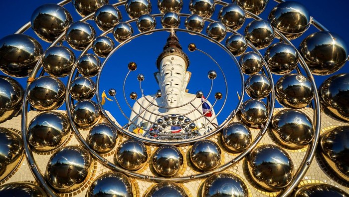 Patung Buddha besar di Wat Phra That Pha Sorn Kaew, Thailand, berdiri megah dengan lima sosok berurutan. Keindahannya berpadu dengan latar perbukitan hijau.