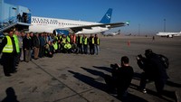 Para pekerja bandara berfoto saat dibukanya kembali penerbangan di bawah penguasa baru Suriah.  