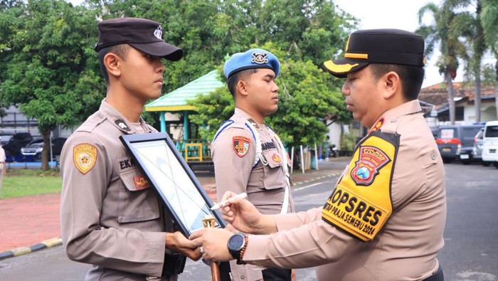 Kapolres Madiun AKBP Muhammad Ridwan mencoret foto Aiptu Parman Budi Santoso yang dipecat karena terlibat peredaran narkoba.
