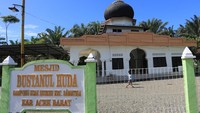 Dua orang anak berada di depan masjid Bustanul Huda yang masih kokoh berdiri setelah dihantam gelombang tsunami pada 26 Desember 2004 di Desa Suak Seukee, Samatiga, Aceh Barat, Aceh, Rabu (18/12/2024).