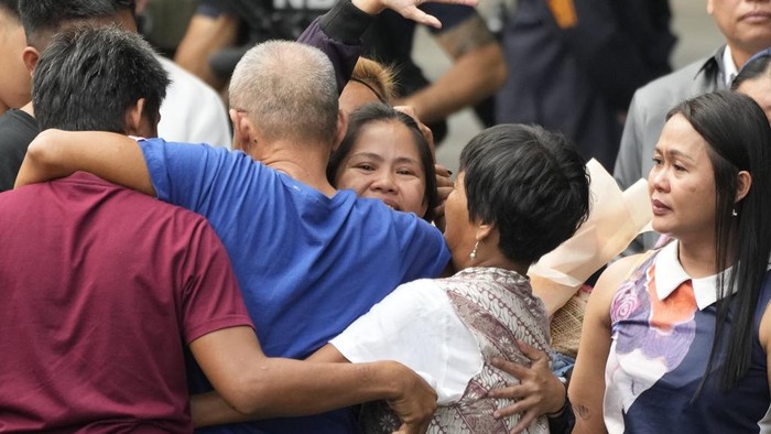 Mary Jane Veloso, a Filipino woman who spent almost 15 years in an Indonesian prison for drug trafficking and was nearly executed by firing squad in 2015, waves to reporters as she is processed at the Correctional Institution for Women in Mandaluyong, Philippines Wednesday, Dec. 18, 2024. (AP Photo/Aaron Favila)