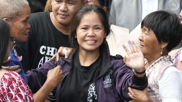 Mary Jane Veloso, a Filipino woman who spent almost 15 years in an Indonesian prison for drug trafficking and was nearly executed by firing squad in 2015, waves to reporters as she is processed at the Correctional Institution for Women in Mandaluyong, Philippines Wednesday, Dec. 18, 2024. (AP Photo/Aaron Favila)