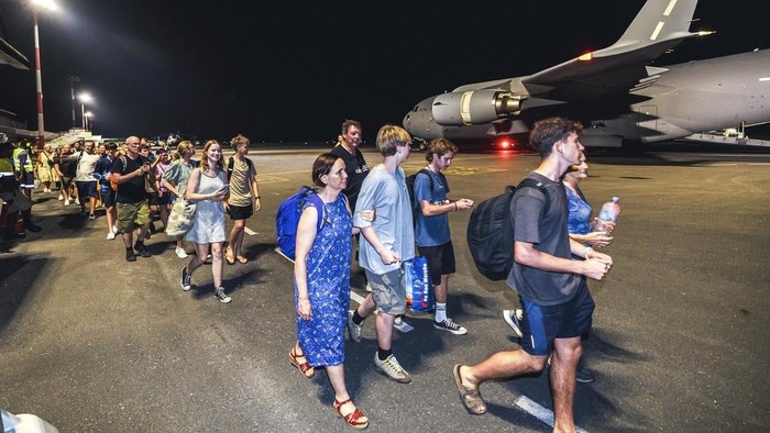 In this photo released by Australian Department of Defence, Australian citizens board a Royal Australian Air Force aircraft for a flight home from Bauerfield International Airport, Port Vila, Vanuatu, Wednesday, Dec. 18, 2024 following a powerful earthquake that struck just off the coast of Vanuatu in the South Pacific Ocean. (CPL Adam Abela/Australian Department of Defence via AP)