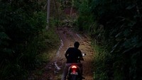 Pengendara motor berhenti di ruas jalan yang tertutup longsor di Dusun Depok, Desa Ngrandu, Trenggalek, Jawa Timur, Rabu (18/12/2024). 