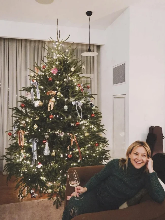 Pohon Natal dengan dekorasi sederhana namun hangat terpajang di rumah aktris Kate Hudson. Bintang film How To Lose A Guy in 10 Days itu pun berpose dengan busana hijau yang serasi dengan pohon Natal di rumahnya. Foto: Instagram