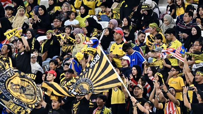 Malaysian supporters are cheering for their team at the AFC U23 Asian Cup Qatar 2024 Group D match between Kuwait and Malaysia at Al Janoub Stadium in Doha, Qatar, on April 23, 2024. (Photo by Noushad Thekkayil/NurPhoto via Getty Images)