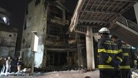 Petugas pemadam kebakaran memeriksa gedung yang terbakar setelah api berhasil dipadamkan di Hanoi, Vietnam, Kamis (19/12/2024).  