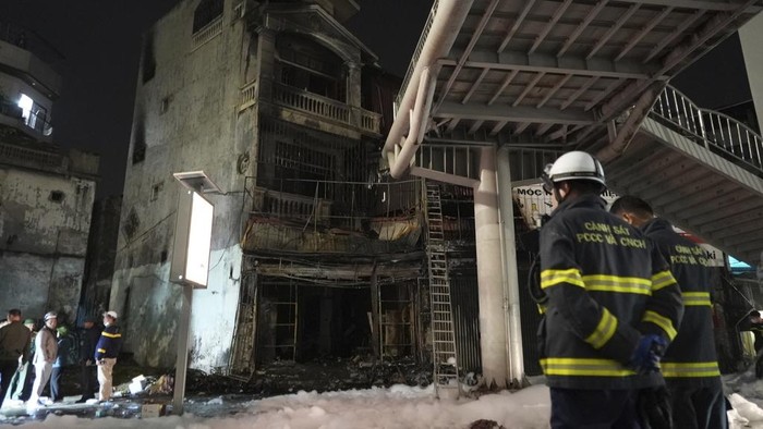 Geger Seorang Pria Bakar Bar Karaoke di Vietnam, 11 Orang Tewas Fire personnel inspect a building burned down by a fire in Hanoi, Vietnam on Thursday, Dec.19, 2024. (AP Photo/Hau Dinh)