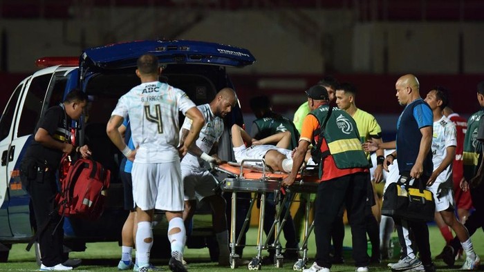 Gelandang Persib Dedi Kusnandar ditandu keluar lapangan gegara cedera patah tulang fibula kaki.